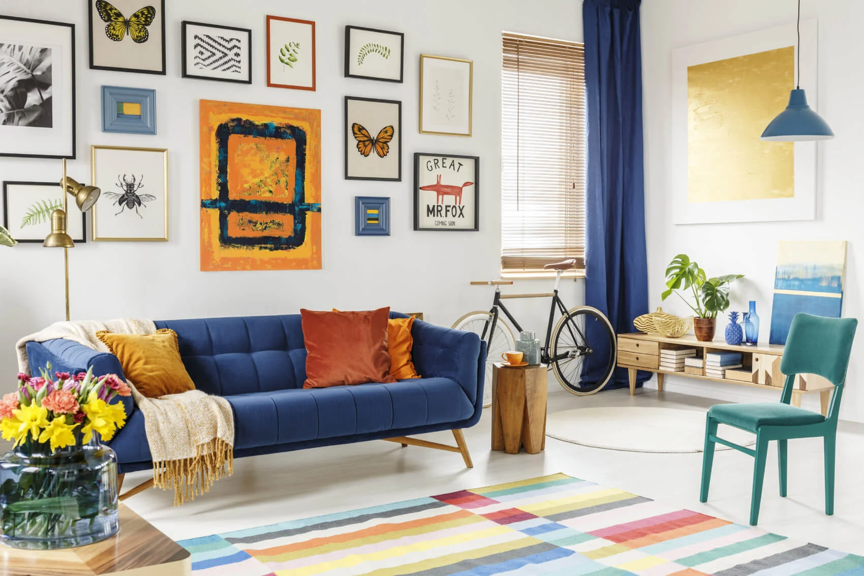 a living room with a blue couch and a table with a bicycle